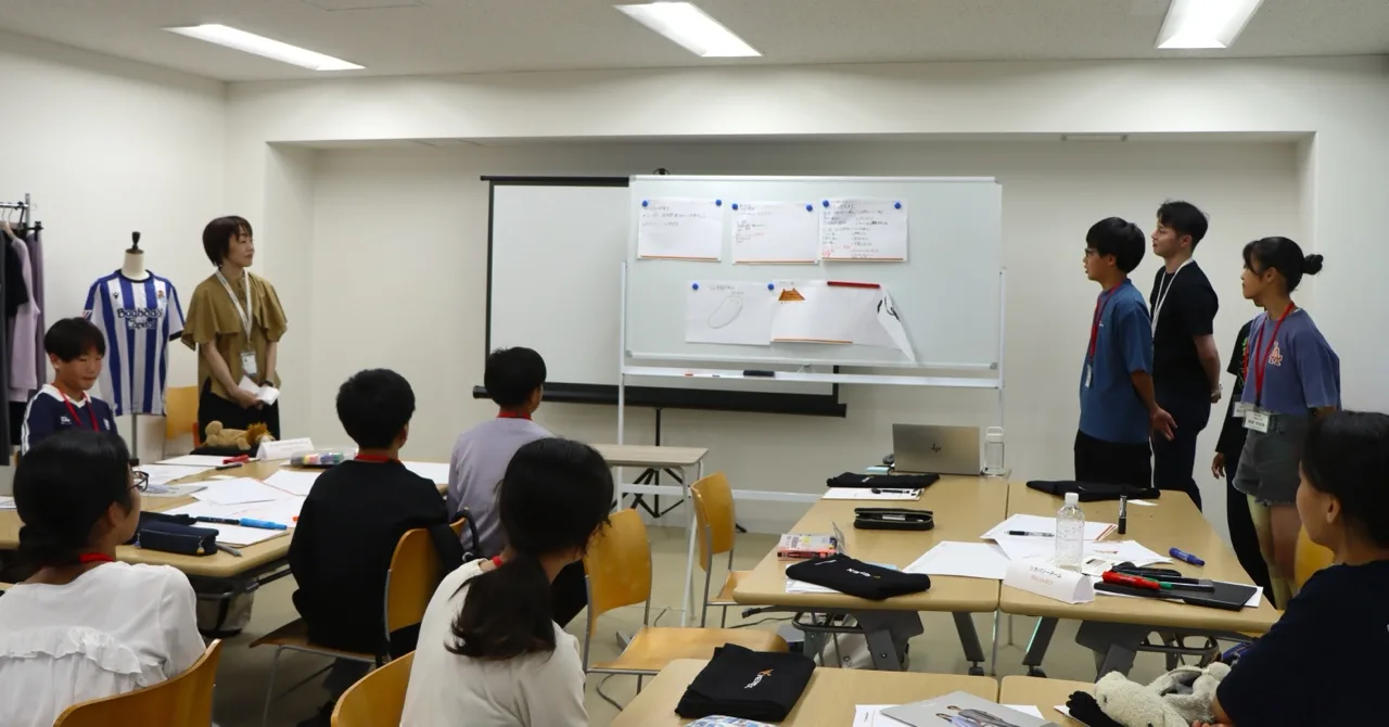 貼り出された企画書の前に並び、発表の順番を待つ生徒たち