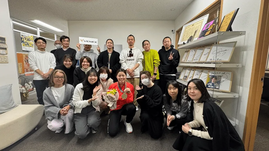 取材後、VENEXスタッフと花束を持って記念撮影する丸山香織選手