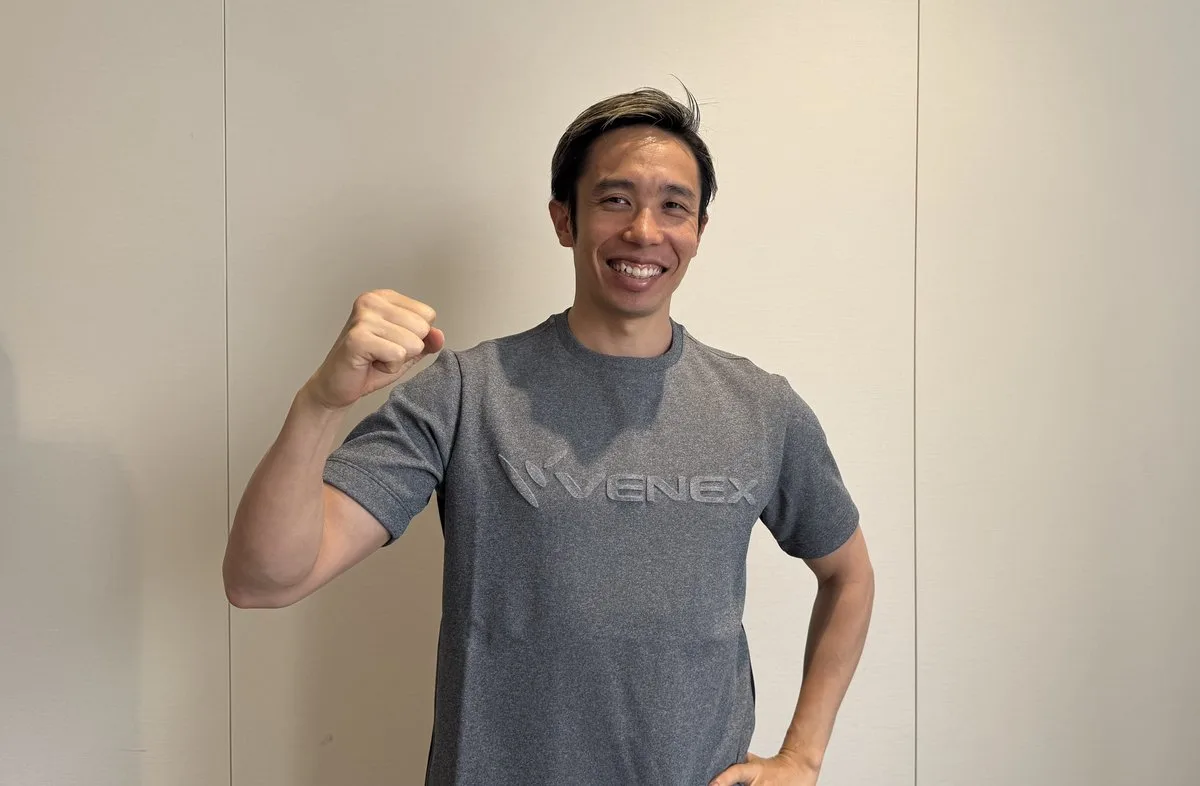 VENEXのTシャツを着てガッツポーズをする富田宇宙選手